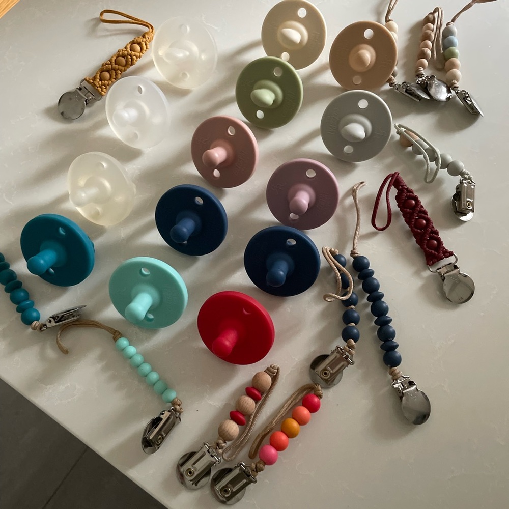 Assorted Ryan and Rose pacifiers and clips